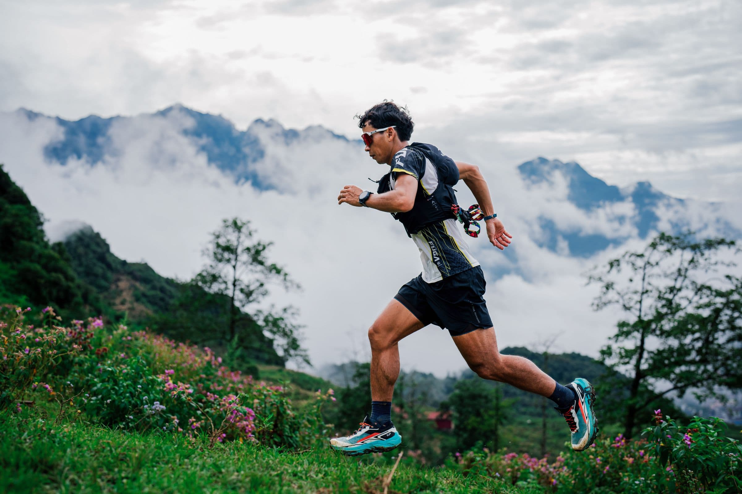 A trail runner striding along a misty mountain ridge